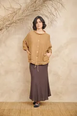 Campera color beige de lino, con cuello mao, mangas 3/4 con botón para sujetar, cierre frontal con botones y ajuste con cordón en la cintura.