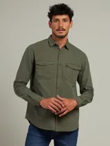 Camisa de manga larga color verde militar, con cuello clásico, cierre frontal con botones y dos bolsillos con solapa abotonada en el pecho.