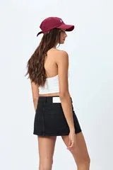 Minifalda de denim negro con diseño de paneles frontales y cierre frontal con botón y cremallera.