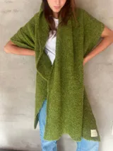 Chal de punto bouclé color marrón claro, hecho de 100% baby alpaca. Tejido suave, esponjoso y cálido, ofrece una textura envolvente y lujosa.