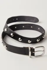 Cinturón de cuero negro con tachas metálicas redondas plateadas a lo largo de toda la tira y hebilla metálica plateada de estilo clásico.