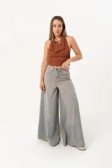 Jean súper campana de tiro alto, color celeste vintage, con pierna extra ancha y caída fluida. Cuenta con bolsillos delanteros y traseros, y cierre frontal con cremallera y botón metálico.