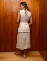 Chaleco de crepe color beige, marca Tahari. Escote en V con solapa y abertura central con botón interno. Cintura con lazo de ajuste. Delantera con bolsillos. Forro interno a tono.