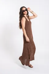 Vestido largo de punto tejido con acabado brillante en tono marrón, sin mangas, con escote redondo y silueta fluida.