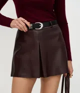 Short de tiro medio confeccionado en poliuretano con acabado que imita el cuero, de corte recto y diseño minimalista. Incluye un cinturón ajustable con hebilla metálica.