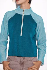 Sweater verde con cierre al cuello, de corte holgado y mangas largas.
