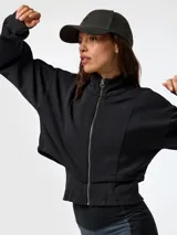 Canguro negro con cremallera, confeccionado en tejido con tecnología Aloe Vera, cuello alto y mangas largas con puños ajustados. Presenta un diseño corto con chaleco incorporado elástico y ajustable en la cintura.