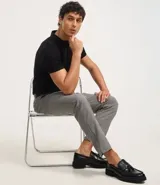 Pantalón de vestir gris con estampado de cuadros en hilo teñido, corte slim, cintura con trabillas, cierre con botón y cremallera.