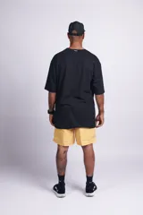 Short de baño amarillo liso con cintura elástica, bolsillos laterales y trasero con velcro, suspensor interno y etiqueta en el frente.