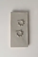 Aros argolla de plata 925 con diseño abierto tipo criolla, decorados con pequeñas esferas en relieve a lo largo del aro.