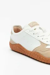 Championes deportivos Paddock modelo Extremes en combinación de colores blanco y beige, con suela de goma texturizada en tono caramelo y cordones blancos.