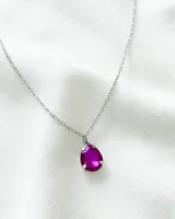 Collar con cadena plateada y dije de cristal fucsia en forma de lágrima.