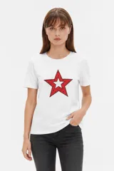 Remera blanca de manga corta y cuello redondo, confeccionada en algodón, con un diseño holgado y estampado frontal de estrella roja con textura y detalles de estrellas pequeñas.