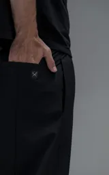 Pantalón cargo de corte oversize confeccionado en microfibra técnica con sutil elasticidad. Presenta cintura elástica, bolsillos laterales y un bolsillo cargo con cierre de broche snap. Incluye un sistema de elásticos con tancas en los tobillos para regular la apertura y la silueta.