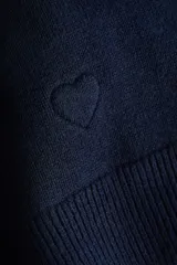 Saco entallado de punto fino, color azul marino, con cuello redondo, cierre frontal de botones y detalle de corazón bordado en el frente.
