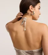 Top halter de tela satinada, color beige con efecto tie-dye/manchas en tonos marrones. Presenta detalles de encaje en el escote y el bajo. El diseño es ajustado al cuerpo.