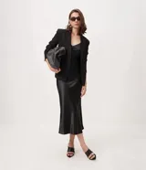 Vestido slip midi satinado color negro, con escote en V, breteles finos regulables y caída fluida.