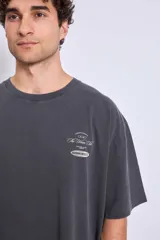 Remera de algodón color marrón con efecto lavado, corte oversize y estampa pequeña en el pecho.