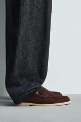 Mocasín casual de hombre, color marrón oscuro (bordó), fabricado en piel con acabado serraje (gamuza). Presenta un detalle de antifaz en el empeine y suela a contraste de color beige claro.