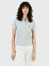 Remera polo celeste de algodón piqué, con cuello clásico y tapeta de dos botones. Tiene mangas cortas con ribete a tono y logo de la marca bordado en el pecho.