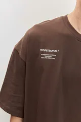 Remera marrón oversize de manga corta, con cuello redondo y pequeños estampados blancos en el pecho.