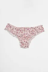 Bombacha de lycra color rosa pálido con estampado de flores pequeñas en tonos fucsia y verde. Tiene volados en la cintura y en las aberturas de las piernas.