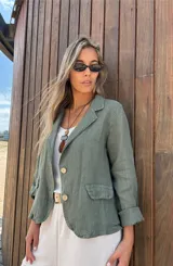 Blazer verde militar de lino con corte entallado, solapas clásicas, cierre con dos botones, bolsillos delanteros y mangas 3/4 con detalle de botón.