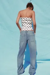 Top blanco con estampado de lunares negros, escote recto, hombros descubiertos y detalle de frunces.