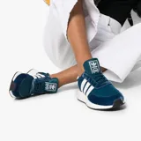 Championes Adidas modelo I-5923, de color azul marino con las icónicas tres tiras laterales en blanco. Presentan una combinación de materiales en la capellada, incluyendo malla y refuerzos de gamuza, montados sobre una entresuela blanca con tecnología Boost para mayor amortiguación.