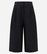 Pantalón pantacourt negro de sarga con largo midi y caída estructurada, cuenta con cintura de terminación limpia y pinzas frontales.