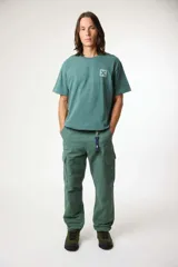 Remera de manga corta color gris, con cuello redondo y un pequeño parche cuadrado con una cruz estampada en el pecho.