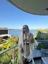 Falda corta color beige, confeccionada en lino, con detalle de puntilla blanca en el ruedo y diseño de corte recto.