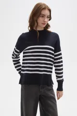 Polera de punto con diseño a rayas horizontales en contraste, cuello alto y mangas largas con puños ajustados.