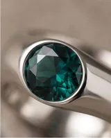 Anillo de plata con cristal de Swarovski verde facetado de forma ovalada, con diseño de sello.