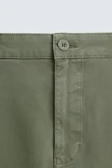 Pantalón chino de corte ajustado, color beige, con bolsillos laterales y bolsillos traseros de vivo. Cuenta con cierre frontal de cremallera y botón.