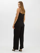 Conjunto monocromático compuesto por un top de breteles finos con escote recto y cierre frontal de botones, y un pantalón de tiro alto con pierna amplia y bolsillos laterales.
