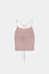 Top crop de tejido de punto con hilo metalizado, diseño de cuello halter y tiras finas cruzadas en la espalda.