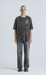 Remera negra con efecto nevado, corte oversize, mangas cortas y cuello redondo. Estampado en la espalda con diseño de una figura femenina y la frase 'Chill Bitch Trust Karma - The Wheel of Fortune'.