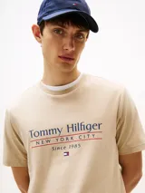 Remera beige de algodón con cuello redondo y logo de Tommy Hilfiger en el pecho.