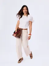 Remera blanca con cuello redondo y mangas cortas abullonadas con detalle de bordado suizo.