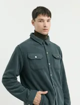 Sobrecamisa de micropolar color terracota, con cuello camisero, cierre frontal con botones a presión y dos bolsillos frontales con solapa y botón.