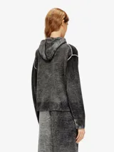 Cardigan de lana color negro con efecto de color irregular y lavado ácido, cuello con capucha y cordones ajustables negros. Posee cierre frontal bidireccional con tirador metálico, bolsillos delanteros tipo canguro y costuras expuestas de alto contraste.