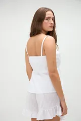 Short de pijama blanco con textura a rayas sutiles, cintura elástica con etiqueta de la marca y detalle de volados en el ruedo.