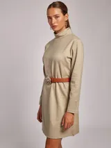 Vestido corto de jersey en color beige, con cuello subido y manga larga. Presenta un corte recto y minimalista.