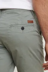 Pantalón de gabardina de corte recto y tiro medio, con bolsillos laterales y traseros, y cierre frontal con botón y cremallera.