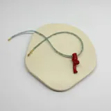 Collar con cuentas de apatita celeste y dije de coral rojo.