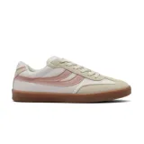 Championes deportivos de mujer, estilo retro/casual, con capellada blanca y detalles en beige y rosado. Presentan un diseño de rayas curvas en el lateral y suela de goma color caramelo.