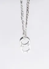 Cadena de acero quirúrgico plateado con eslabones tipo fígaro y dije con forma de chapita con dos círculos calados y estrellas grabadas.