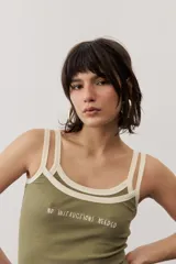 Musculosa de tejido rib color beige con detalles en marrón oscuro en el escote y doble tirante fino. Presenta un pequeño texto estampado en el pecho.