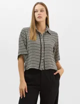 Camisa de corte holgado y silueta recta con estampado geométrico bicolor de eslabones. Presenta cuello camisero clásico, mangas cortas amplias y cierre frontal con botones y vivos a contratono.